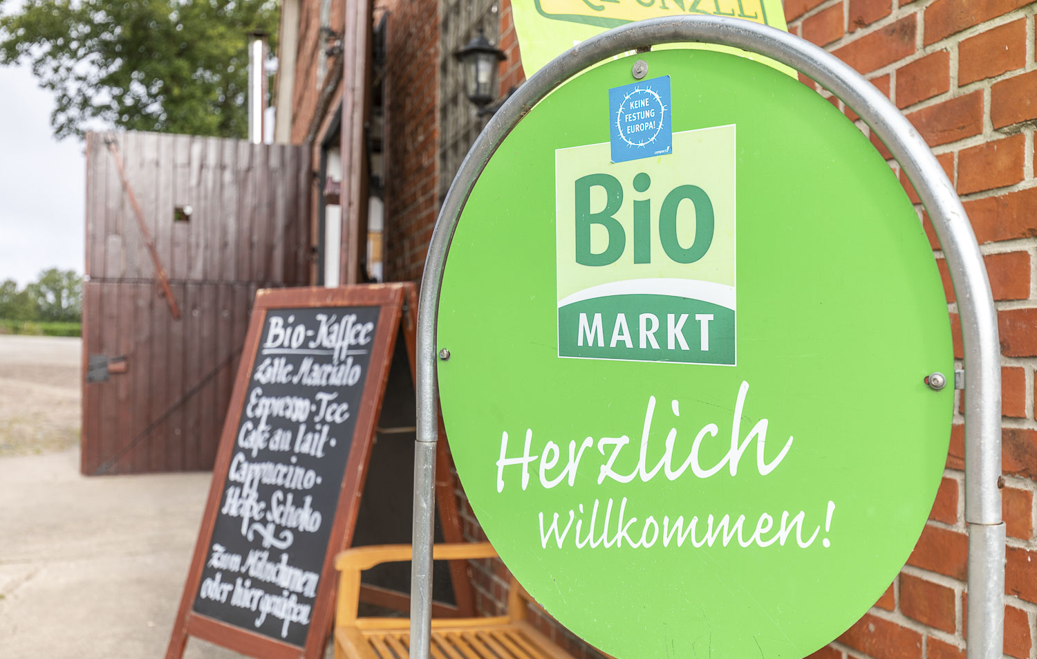 Grünes Willkommensschild vor dem Naturkostladen Häcklingen, Ihr Bio-Markt in Lüneburg